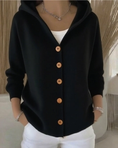 Detailaufnahme der natürlichen Holzknöpfe und weichen Stricktextur auf schwarzer Strickjacke