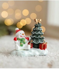 Figurine de Noël miniature en résine avec bonhomme de neige et sapin sur fond bokeh