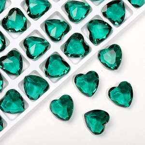 Detailed view of 12mm emerald green heart-shaped crystal rhinestones with faceted finish