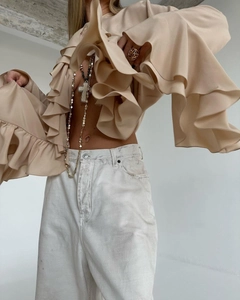 Detail view of beige ruffle blouse with layered flare sleeves and elegant fabric texture