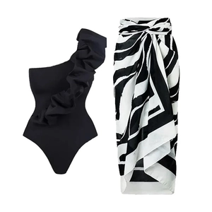 Detail of one-shoulder ruffle swimsuit with zebra pattern wrap skirt on white background