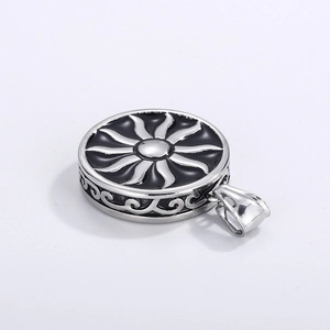 Macro de pendentif soleil argenté avec motifs de flammes noires et détails de nuages