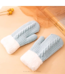 Dettaglio di muffole in maglia azzurra con polsini in morbida pelliccia sintetica bianca
