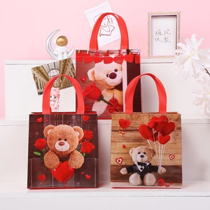 Three-piece Valentine Teddy Bear non-woven gift bags set with red handles on a pink display