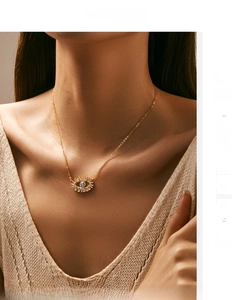 Detail of S925 sterling silver evil eye necklace with blue stone on a female model