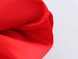 Vue macro détaillée de la texture du tissu rouge et des coutures de l'ourlet à volants