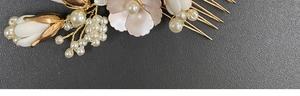 Detail of bridal hair comb with pearls and porcelain flowers on golden metal base