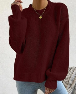 Close-up of the chunky knit texture and loose fit on a maroon long sleeve sweater