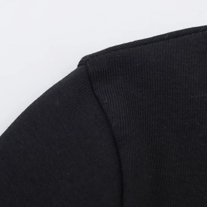 Dettaglio macro della cucitura rinforzata sulla spalla della maglietta in maglia nera