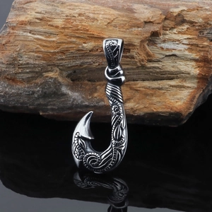 Vintage stainless steel fish hook pendant necklace with intricate engravings on black surface