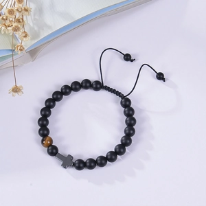 Detail of 8mm matte black stone beads with tiger eye accent and alloy cross on card