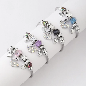 Detail of beaded bracelets with swan, heart, and clover charms on a display stand