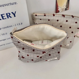 Close-up of checkered polka dot makeup bag with bow detail and metal zipper