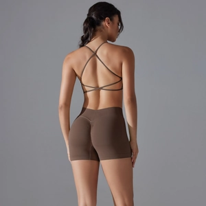 Detail of dark brown yoga set featuring cross-back sports bra and ruched lifting shorts