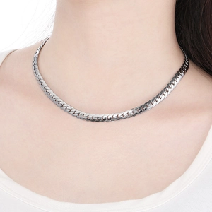 Close-up of a silver flat Cuban link snake chain necklace on a model's neck