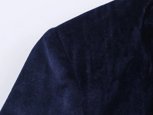 Detail of the navy velvet blazer shoulder seams and fabric texture on white background