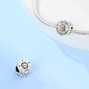 Dettaglio macro di ciondoli in argento S925 con incisioni Sun e Love su catena snake