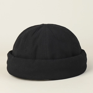 Close-up of black cotton docker cap showing vertical stitching and wide rolled edge detail