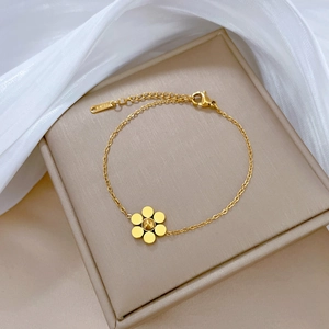 Detail of golden flower chain bracelet in titanium steel with lobster clasp and extension