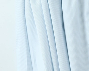 Gros plan macro du tissu bleu clair montrant le tissage sergé et le drapé fluide