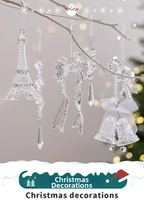 Macro shot of clear acrylic Eiffel Tower and bell ornaments with silver glitter finish