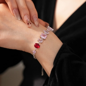Detail of vintage silver bracelet featuring red oval and pink marquise zircon stones