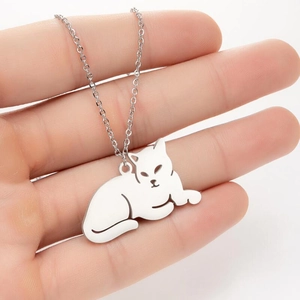 Collier avec pendentif chat argenté sur la main, bijou chaton creux au style épuré
