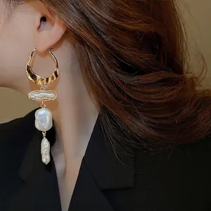 French baroque pearl tassel earrings with irregular gold hoops on a fashion model