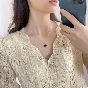 Close-up of minimalist 925 silver necklace with a black zircon mini padlock pendant