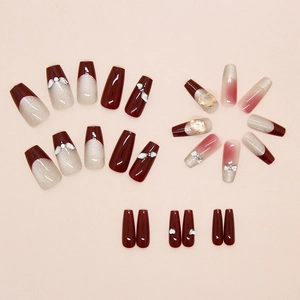 Macro detail of wine red cat eye press-on nails with sparkling rhinestones and pearls