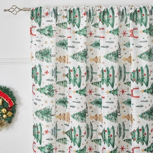 Detail of Christmas themed curtains featuring tree prints and festive lettering on white fabric