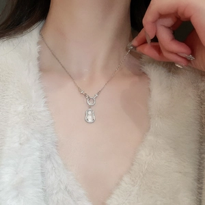 Detailed close-up of a zircon gourd pendant necklace on a soft white plush background
