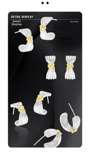 Detailed close-up showing ribbed texture and gold knot on silver ribbon earrings