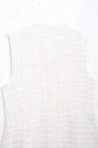 Close-up of the back of white tweed vest featuring thick woven texture and clean finish
