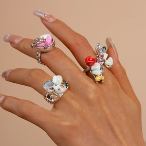Detail of artistic silver textured rings with colorful shell and gemstone accents on hand