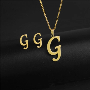 Detailed macro view of the gold G-letter pendant necklace and stud earrings set
