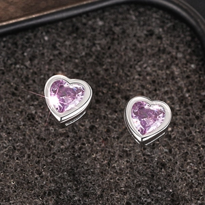 Macro shot of polished silver heart stud earrings with sparkling pink zirconia stones