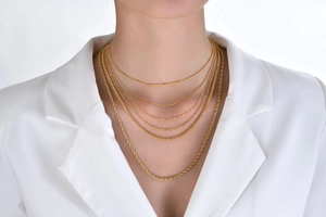 Detailed view of layered 18k gold plated titanium steel necklaces featuring snake and rope chains