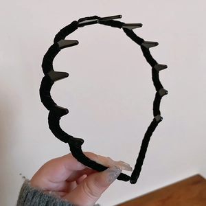 Close-up of black velvet-flocked wavy headband featuring non-slip teeth for secure grip