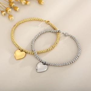 Gold and silver stainless steel beaded bracelets with heart pendants in a minimalist set