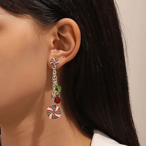 Close-up of dangling peppermint candy earrings with red and green beads on a model