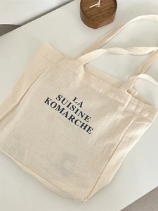 Minimalist off-white canvas tote bag with black letter print for daily commute