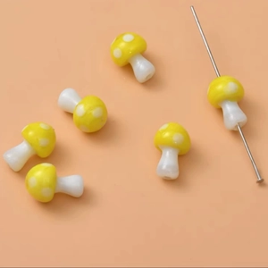 Detailed macro view of yellow mushroom glass beads with white spots for DIY jewelry