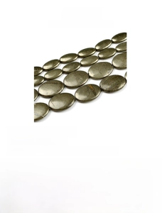 Makro-Detail von ovalen Pyrit-Edelsteinperlen mit natürlichem Metallglanz und Textur