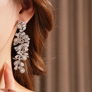 Gros plan détaillé de boucles d'oreilles élégantes en zircon portées par un modèle