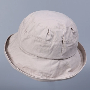 Detail view of beige cotton bucket hat with sun-protective brim and stitched texture