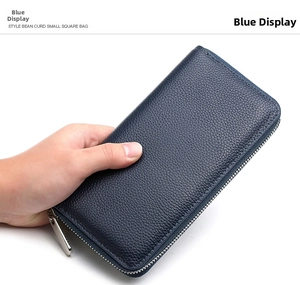 Close-up of hand holding a blue litchi pattern leather wallet with silver zipper
