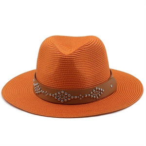 Detail of orange straw fedora hat with brown leather band and silver metal studs