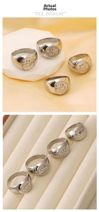 Detailed view of silver stainless steel lion emblem coin rings on display stand