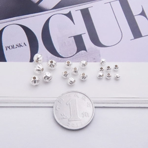 Macro shot of S925 sterling silver striped beads with a coin for size comparison